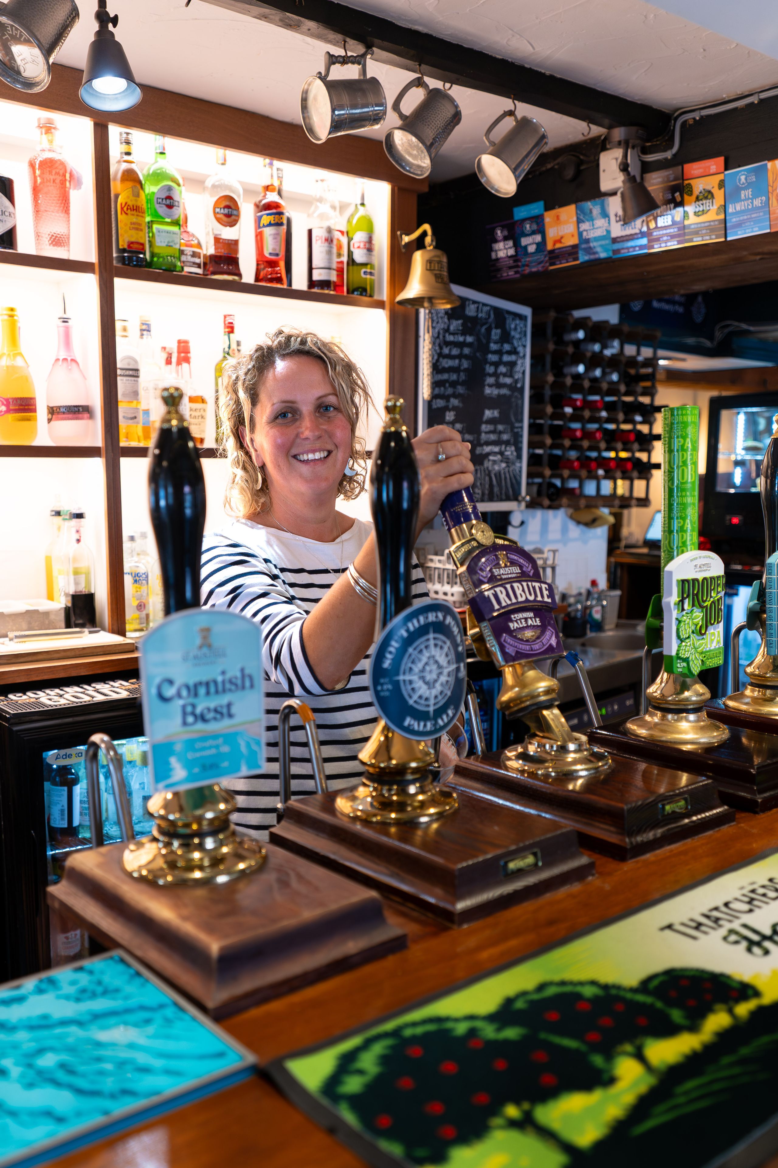 Person pulling pint behind the bar