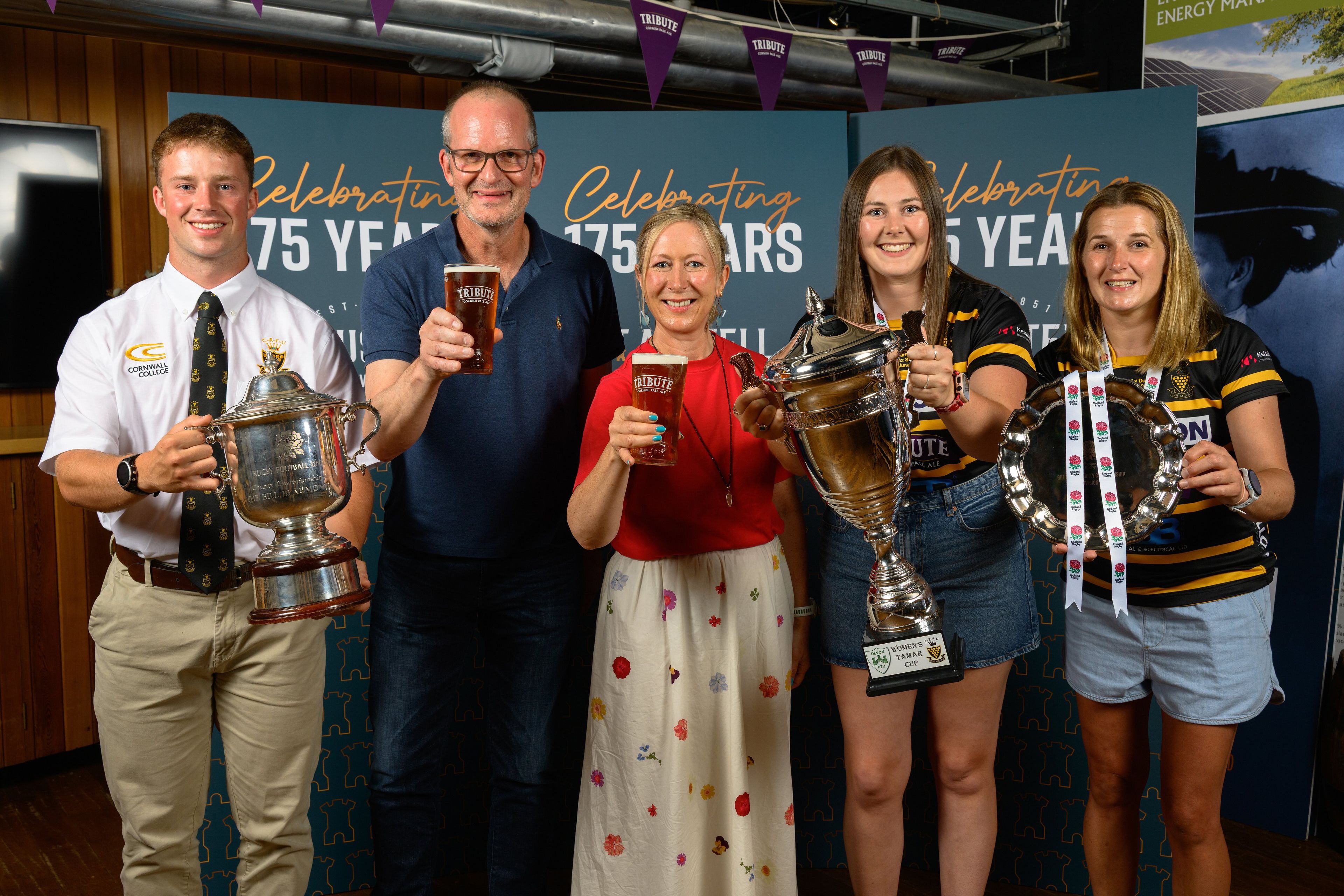 St Austell Brewery team members pose alongside the players whilst holding up the trophies and pints of Tribute